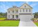 Two-story farmhouse with white siding, a large driveway, and landscaping at 173 Fiddleback Dr, Summerville, SC 29486
