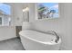 Bright bathroom showcases a freestanding tub, wainscoting, and a large window for natural light at 1075 Capersview Ct, Awendaw, SC 29429