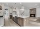 Open-concept kitchen with an island, stainless steel appliances, and a cozy fireplace nearby at 1075 Capersview Ct, Awendaw, SC 29429