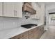 Well-equipped kitchen showcasing a range hood, white countertops, and stainless steel appliances at 1075 Capersview Ct, Awendaw, SC 29429