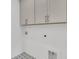 Functional laundry room with upper cabinets and modern tile flooring at 1075 Capersview Ct, Awendaw, SC 29429