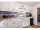 White cabinets and wood-look floors are featured in this galley-style kitchen at 175 Maria Stuart Ln, Varnville, SC 29944