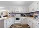 Efficient kitchen with white cabinets and wood-look flooring at 175 Maria Stuart Ln, Varnville, SC 29944