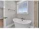 Bright bathroom featuring a white freestanding tub, brushed gold hardware, and tile flooring at 1153 Oak Bluff Ave, Charleston, SC 29492