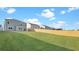 Backyard view features a well-maintained lawn, wooden fence, and a light blue house at 220 Maple Hill Dr, Moncks Corner, SC 29461