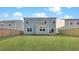 Backyard view features a well-maintained lawn, wooden fence, and a light blue house at 220 Maple Hill Dr, Moncks Corner, SC 29461
