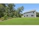 Spacious backyard featuring a lush lawn, mature trees, and a charming two-story home with light-blue siding at 127 Morning View Way, Moncks Corner, SC 29461