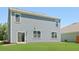 Home backyard featuring lush green lawn and light blue siding with door and windows at 127 Morning View Way, Moncks Corner, SC 29461