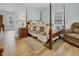 Bedroom with wooden post bed, armchair, and ample natural light at 8375 Shell House Rd, Edisto Island, SC 29438