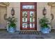 Elegant home entrance with double doors, lanterns, and lush greenery at 633 Barbados Dr, Charleston, SC 29492
