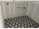 A modern laundry room with black, white, and gray honeycomb tile flooring at 1556 John Fenwick Ln, Johns Island, SC 29455