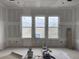 Bright living room featuring three large windows overlooking a scenic outdoor view at 1556 John Fenwick Ln, Johns Island, SC 29455