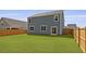 Large, fenced backyard with lush green grass and a sliding glass door entry to the home at 142 Morning View Way, Moncks Corner, SC 29461