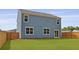 A fenced backyard with well-maintained grass and the exterior of a two story home at 142 Morning View Way, Moncks Corner, SC 29461