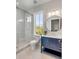 Beautiful bathroom featuring a glass shower, blue vanity, round mirror, and natural light at 34 Waterway Island Dr, Isle of Palms, SC 29451