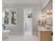 Bright bathroom featuring a soaking tub, marble countertop, and modern gold fixtures, with natural light from large windows at 34 Waterway Island Dr, Isle of Palms, SC 29451