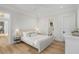 Bright bedroom with ensuite bathroom features a bed with lamps and hardwood floors at 34 Waterway Island Dr, Isle of Palms, SC 29451