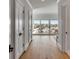 Hallway leading to a private balcony with views of the marina and featuring light hardwood floors and white walls at 34 Waterway Island Dr, Isle of Palms, SC 29451