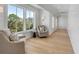 Bright hallway with white shiplap walls, hardwood floors and large windows that offer a view of the green, lush outdoors at 34 Waterway Island Dr, Isle of Palms, SC 29451