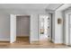 Hallway with a door opening to a modern bathroom, featuring warm lighting and light hardwood floors at 34 Waterway Island Dr, Isle of Palms, SC 29451