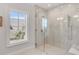 Luxurious marble-tiled shower with glass enclosure and natural light from the adjacent window at 34 Waterway Island Dr, Isle of Palms, SC 29451
