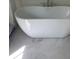 A modern bathroom with a sleek white soaking tub and marble tile flooring at 1560 John Fenwick Ln, Johns Island, SC 29455