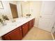 Double vanity bathroom with dark wood cabinets and neutral tile floors at 8897 Cat Tail Pond Rd, Summerville, SC 29485