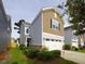 Two-story house with gray and brown siding, a two-car garage, and well-maintained landscaping at 8897 Cat Tail Pond Rd, Summerville, SC 29485