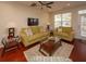 Living room features hardwood floors, olive green sofas, and a ceiling fan at 8897 Cat Tail Pond Rd, Summerville, SC 29485