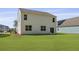 Backyard of a white house with a large lawn and blue house nearby at 132 Morning View Way, Moncks Corner, SC 29461