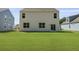 Backyard of a white house with a large lawn and blue house nearby at 132 Morning View Way, Moncks Corner, SC 29461