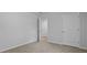 An empty bedroom featuring a light colored carpet, base trim, neutral wall paint and two doors at 132 Morning View Way, Moncks Corner, SC 29461