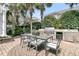 Lovely outdoor kitchen with gas grill, mini-refrigerator, dining table and patio made of brick pavers at 143 Island Park Dr, Charleston, SC 29492