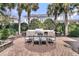 Beautiful outdoor kitchen featuring a gas grill, dining table and patio made of brick pavers at 143 Island Park Dr, Charleston, SC 29492