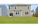 Back exterior view of home featuring a large lawn, neutral siding, white trim, and sliding glass doors at 159 Morning View Way, Moncks Corner, SC 29461