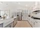 White kitchen features a farmhouse sink, stainless steel appliances, and light hardwood floors at 134 Cantona Dr, Summerville, SC 29483