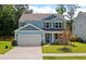 Two-story light blue house with gray shutters, white garage door, and landscaped lawn at 208 Cherry Grove Dr, Summerville, SC 29483