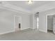 Large bedroom with neutral paint and carpet, featuring multiple doorways and tray ceiling at 371 Wappoo Trace Ln, Summerville, SC 29486