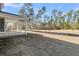 Spacious backyard featuring lush grass, a covered patio, and distant trees under a bright sky at 383 Wappoo Trace Ln, Summerville, SC 29486