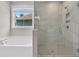 Beautiful bathroom featuring a glass shower with tile surround and a soaking tub with a window view at 383 Wappoo Trace Ln, Summerville, SC 29486