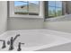 Close up of a soaking tub with sleek faucet fixtures, with a window view at 383 Wappoo Trace Ln, Summerville, SC 29486