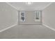 Neutral bedroom with carpet flooring and two windows overlooking a wooded area at 383 Wappoo Trace Ln, Summerville, SC 29486