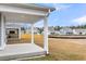 Backyard view with concrete patio, white pillars and other houses in the background under a blue sky at 710 Maynard Ln, Summerville, SC 29486