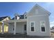 Charming single Gathering home featuring light gray horizontal siding, white trim, dormer windows and a covered front porch at 407 Swaying Pine Ln, Summerville, SC 29486