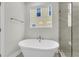 Bright bathroom featuring a freestanding tub, a shower with glass surround, and a window at 704 Maynard Ln, Summerville, SC 29486