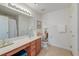 Well-lit bathroom with a large mirror, tiled floor, and combination shower and tub at 7034 Lanier St, Hanahan, SC 29410