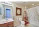 Bright bathroom with a sink, toilet, and shower with a unique framed mirror at 7034 Lanier St, Hanahan, SC 29410