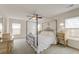 Bright bedroom featuring a canopy bed, ceiling fan, and soft natural light through the windows at 7034 Lanier St, Hanahan, SC 29410