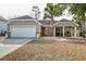 Inviting home exterior featuring a charming front porch, a garage, and stone accents at 7034 Lanier St, Hanahan, SC 29410