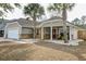 Charming home featuring a cozy front porch adorned with decorative stone and landscaped with palm trees at 7034 Lanier St, Hanahan, SC 29410